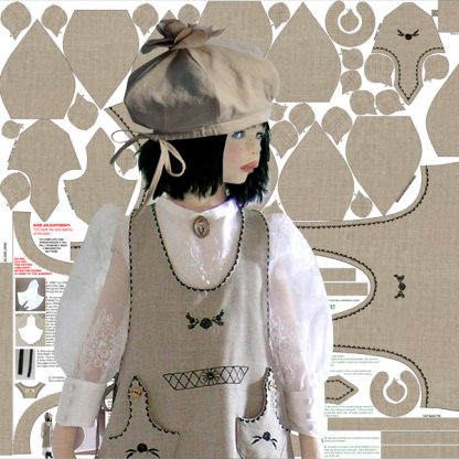child in apron and hat in front of pattern printed on fabric